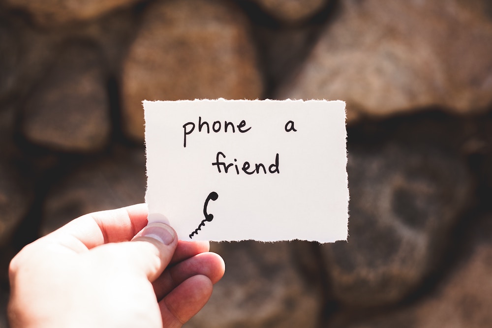 hand holding paper that says phone a friend